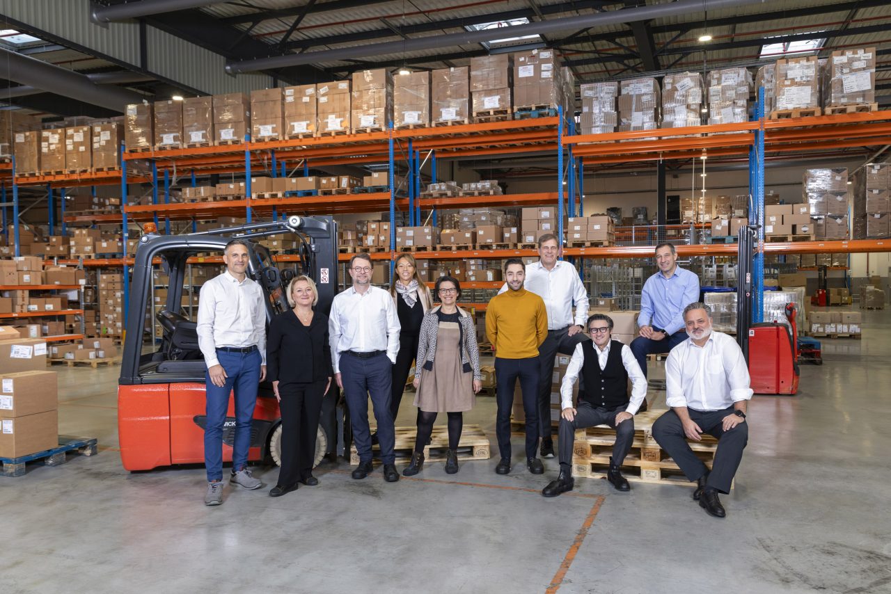 Photo d'un COMEX de 10 personnes à l'intérieur d'un entrepôt logistique d'une entreprise