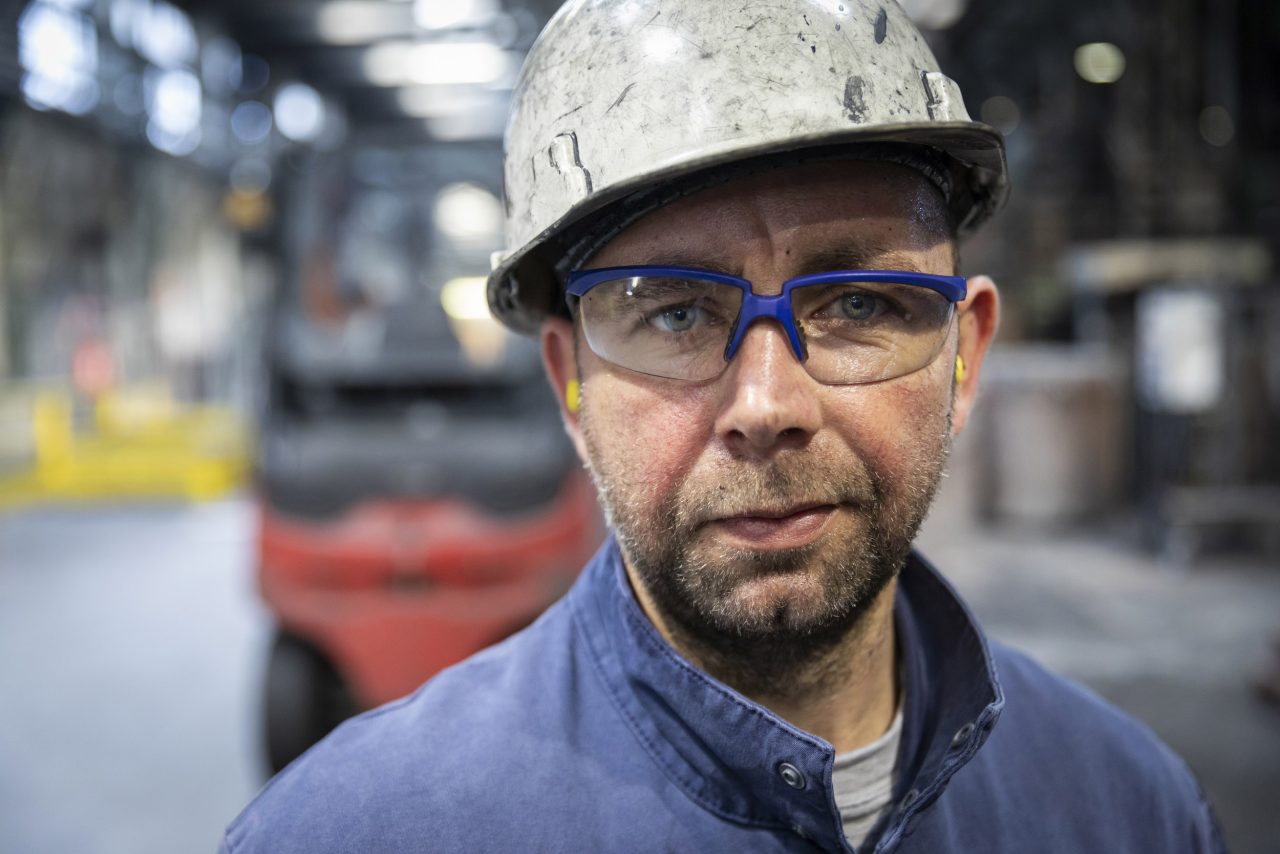 Portrait métier d'un homme dans l'industrie portant casque, lunettes et bouchons d'oreilles
